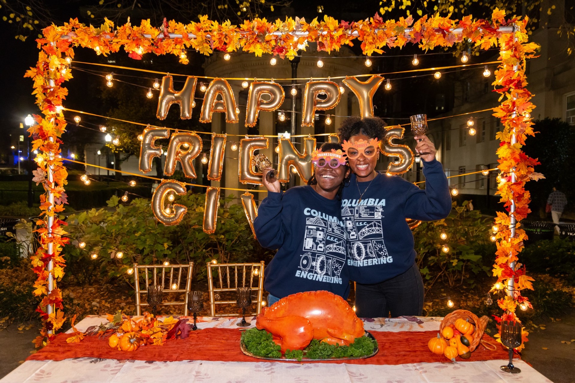Two students posing at the photo booth at Friendsgiving 2023