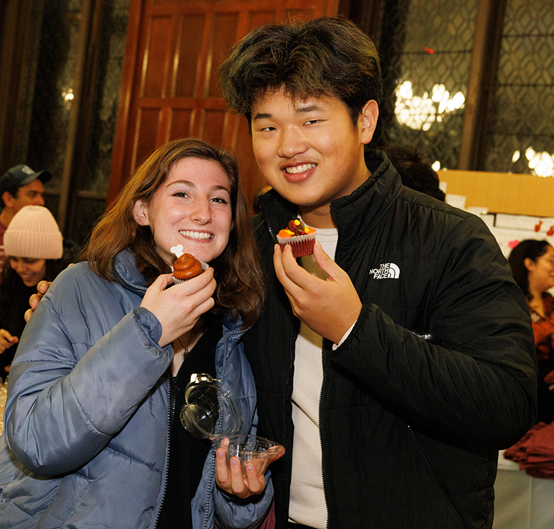 Two students holding cupcakes