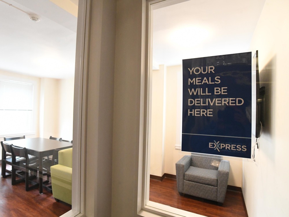 Designated delivery locations within each floor of the residence halls. (Photo: Eileen Barroso) A sign attached to the window of a student lounge that reads, "Your meals will be delivered here - Express."