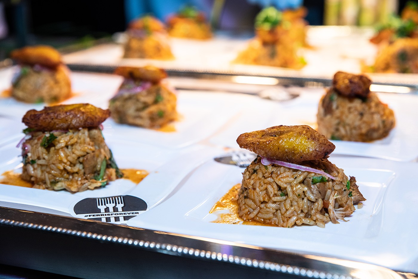 plates of arroz con pollo topped with plantains