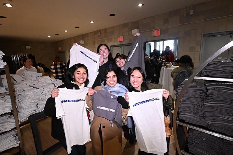 Students holding up t-shirts