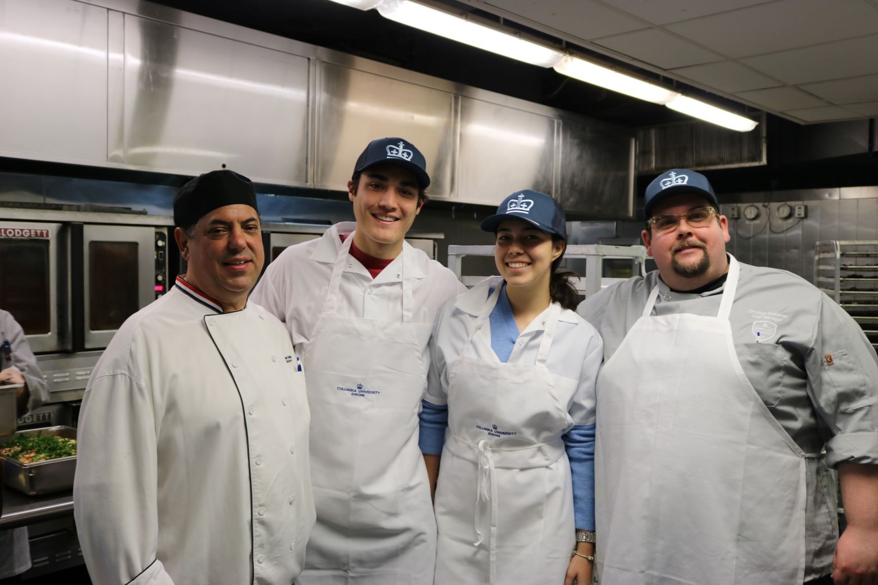 Teodora with John, Chef Mike, and Chef Christian in the John Jay kitchen ready to prep dinner