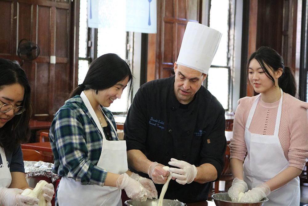Don demonstrates how to make bocconcini, meaning “small mouthfuls,” which are smaller, bite-sized forms of mozzarella. Chef Don shows a student how to break the mozzarella into a small ball