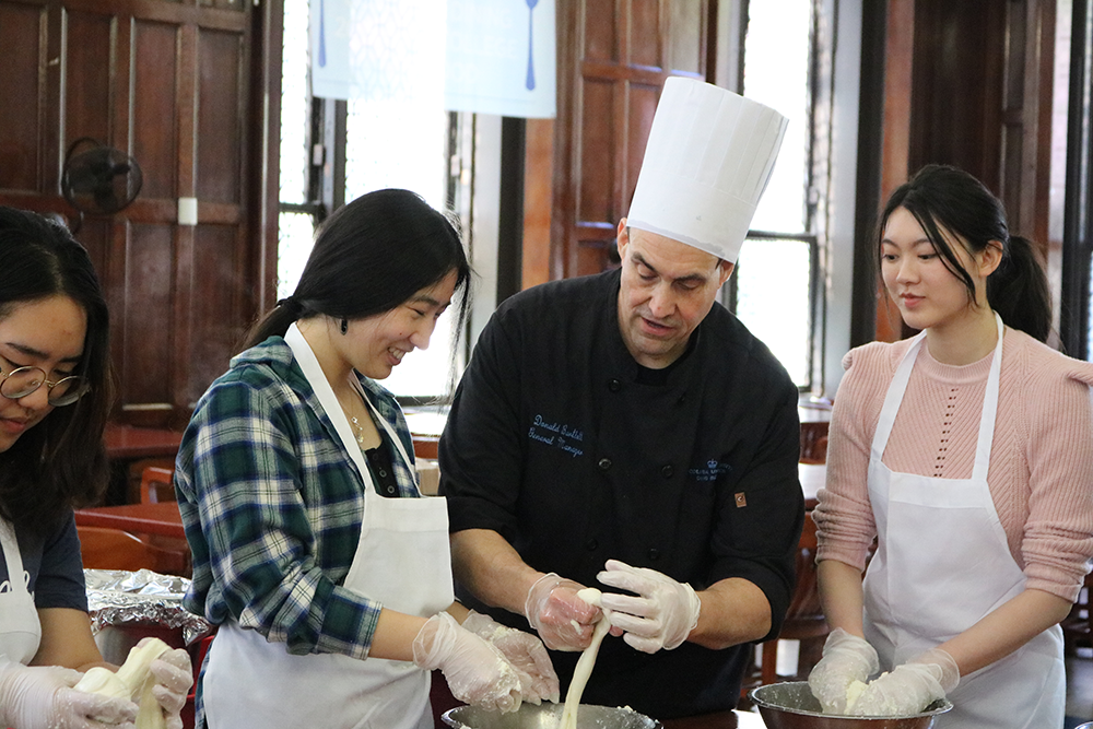 Chef Don shows a student how to break the mozzarella into a small ball