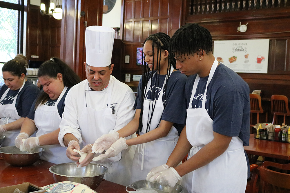 Chef Mike showing two students how to knead their mozzarella