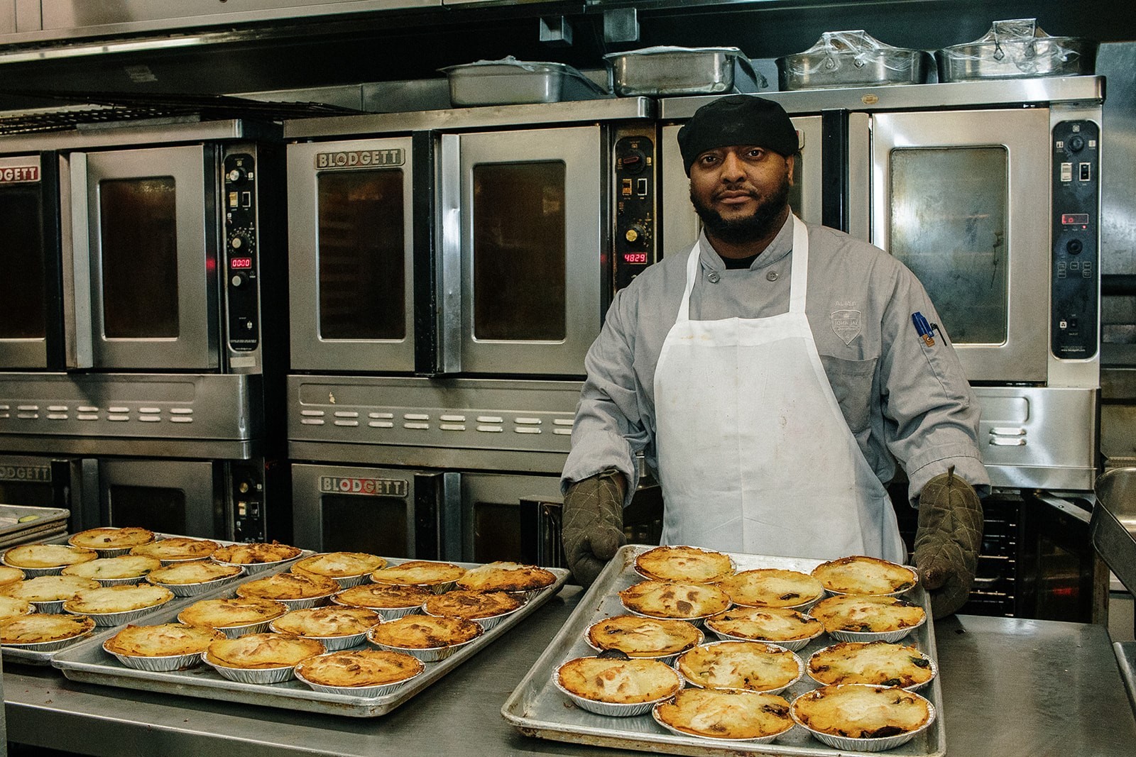 Austin pulls a tray of fresh-basked moussaka from the oven; photo by April Renae