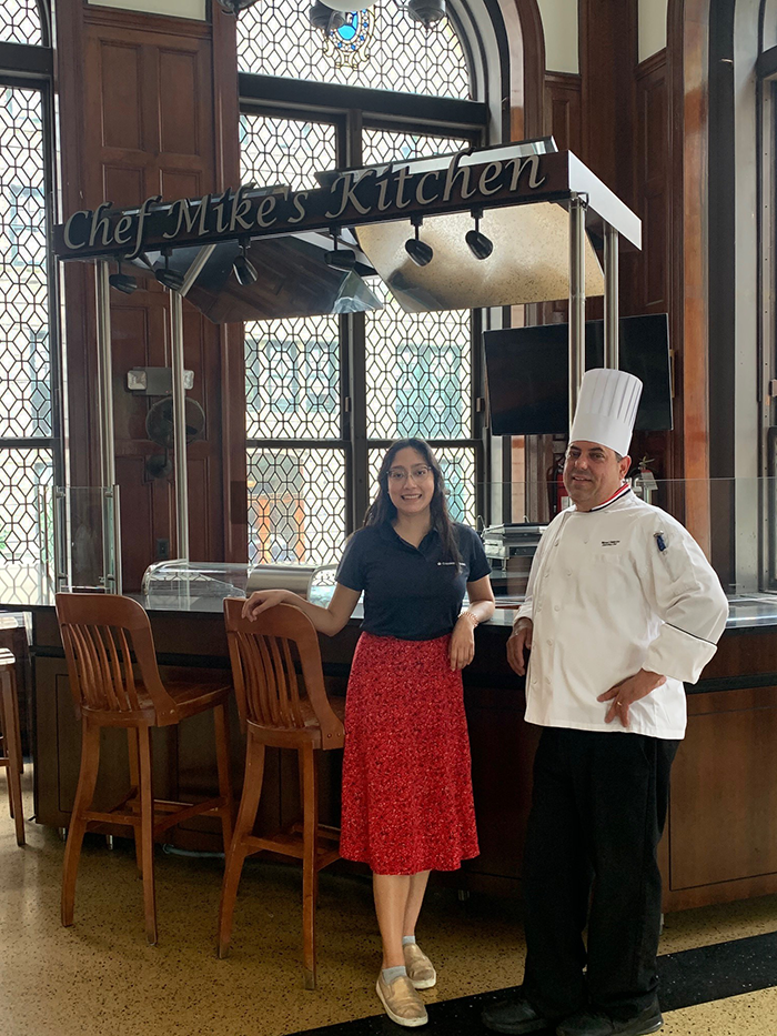 Alexa and Mike standing in front of Chef Mike's station in John Jay Dining Hall