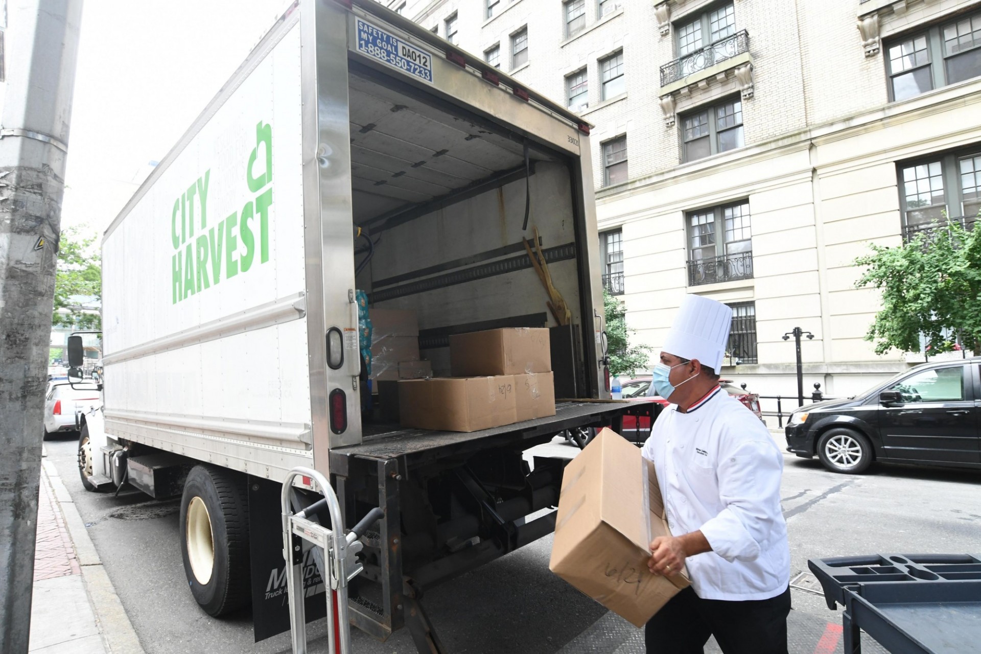 Chef Mike loads boxes of food into a waiting City Harvest truck