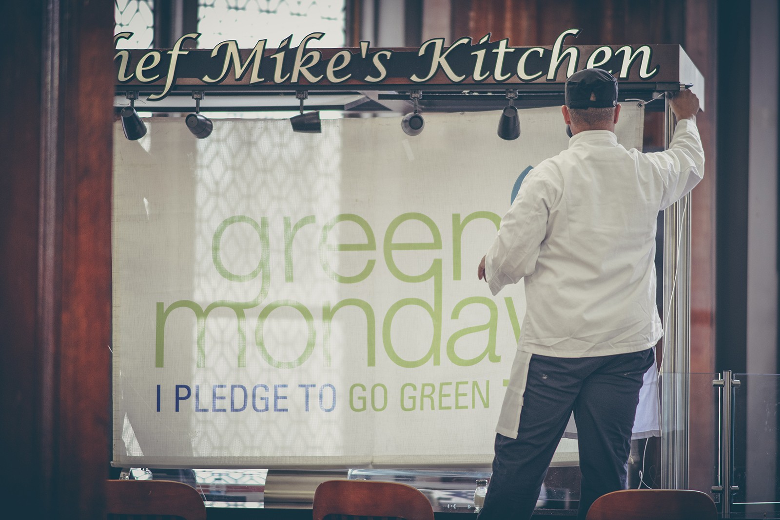 Hanging a banner promoting Green Monday in Columbia's John Jay Dining Hall.