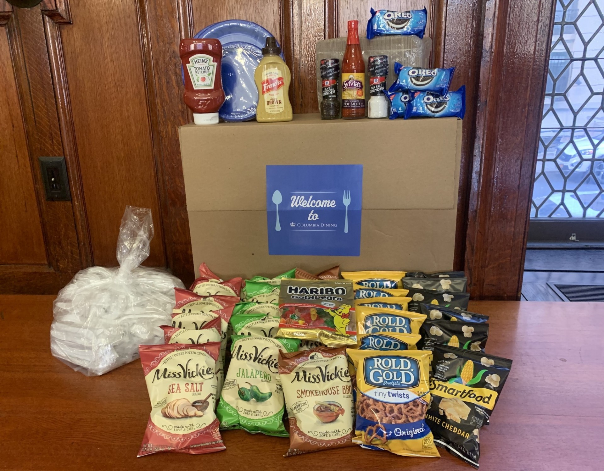 A Welcome Columbia Dining Box with all of its contents - snacks, disposable flatware, condiments and more.