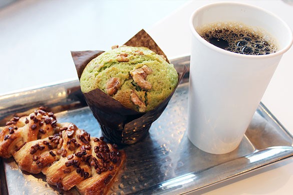 Photo of pistachio muffin, black coffee in a cup, and breakfast pastry with nuts