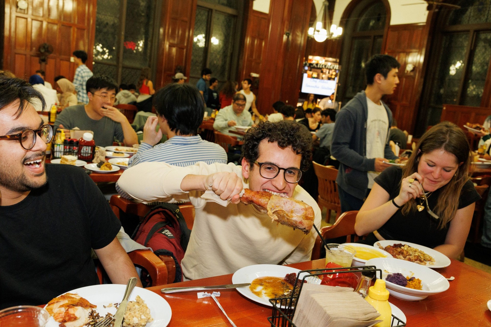 Enjoying every delicious bite of Thanksgiving delight student eating a turkey leg