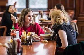 two female students chatting while eating