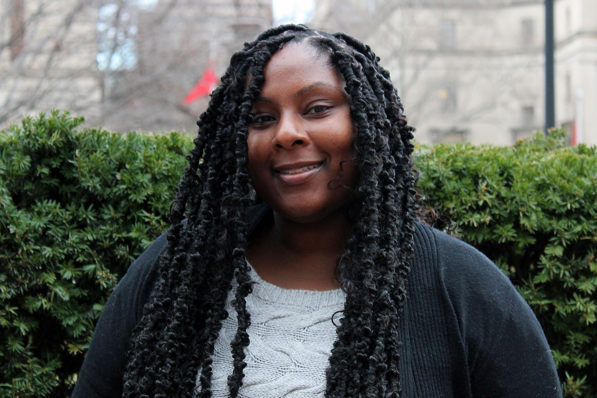 Head shot of Dionne Douglas on campus in front of shrubbery