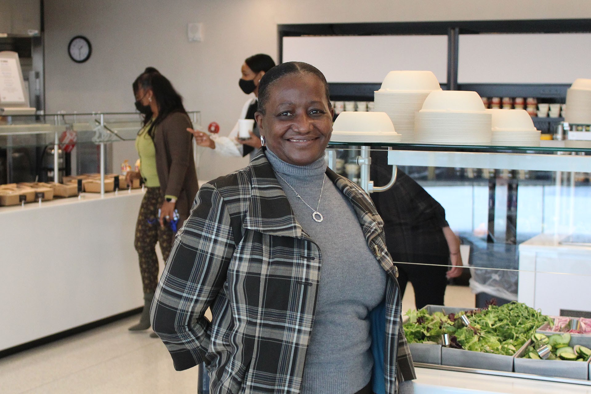 Photograph of Hazel in the dining hall in front of the salad bar