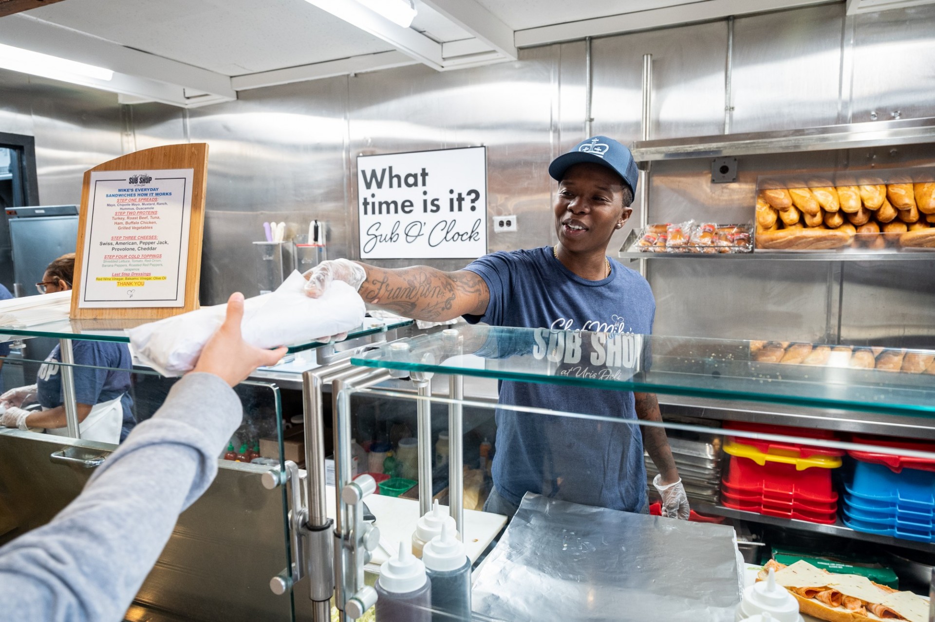Chef Mike's Sub Shop employee handing a sandwich to a student