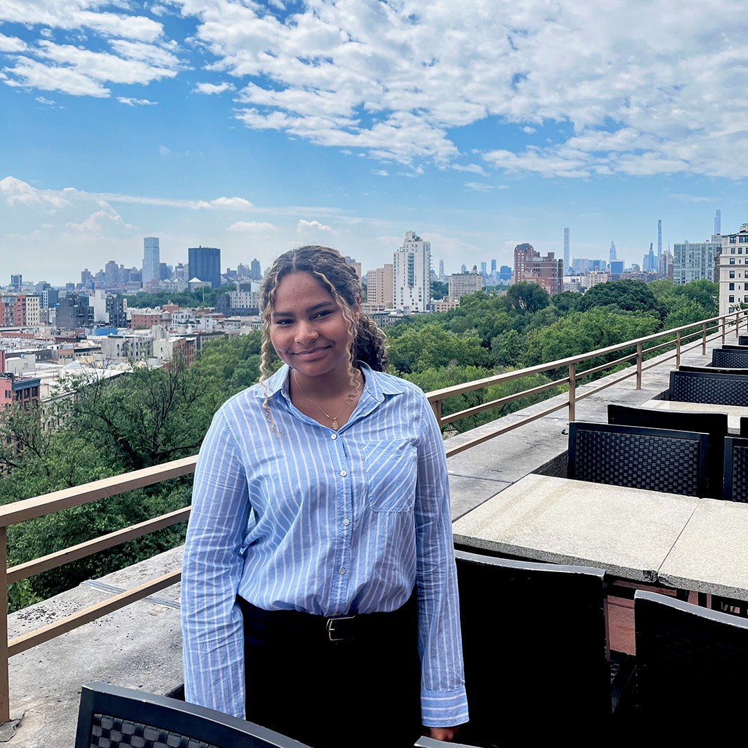 Brittany standing on the Faculty House terrace with the manhattan skyline in the background