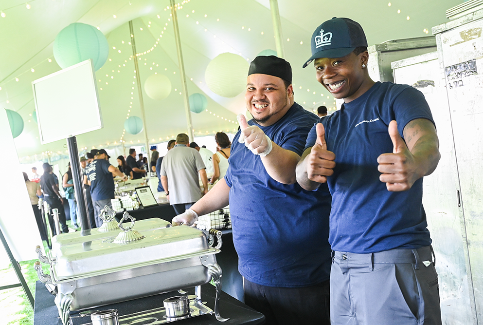 Two Dining staff members give thumbs up to the camera