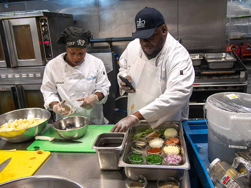 Staff in the John Jay kitchen preparing a dish