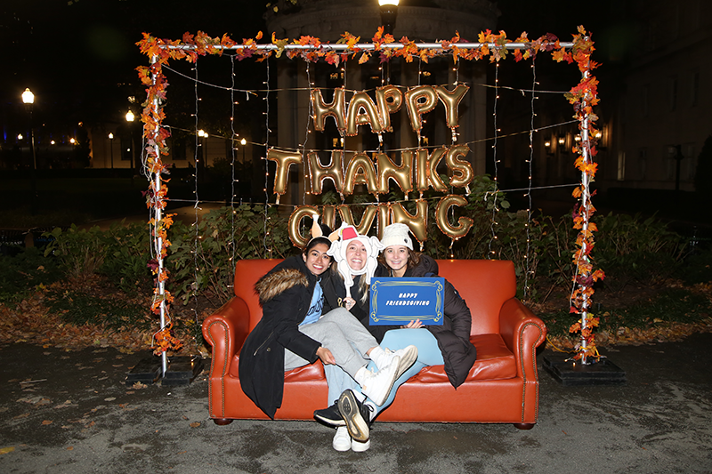 Students sitting on the couch at the photo booth