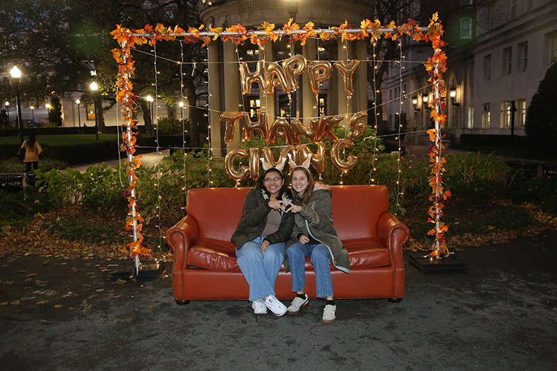 Students sitting on the couch at the photo booth