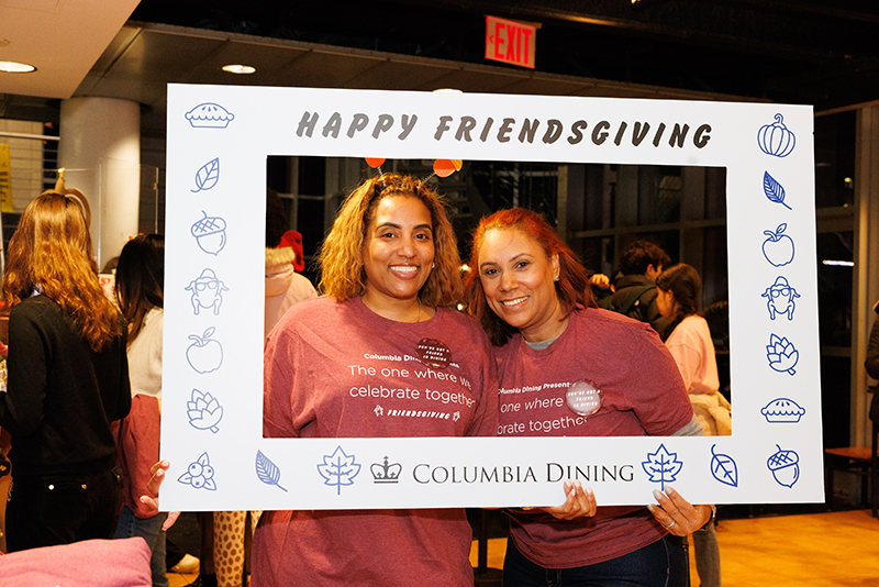 Happy Friendsgiving from Kellen and Altagracia Ferris staff pose with the Friendsgiving photo frame