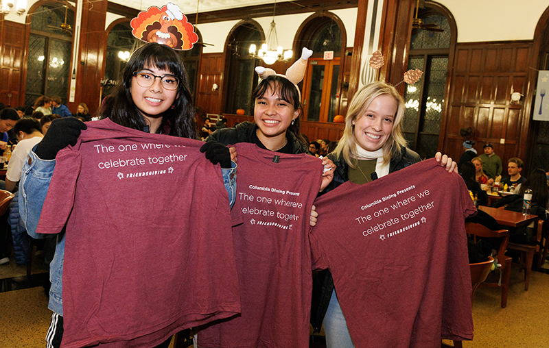Three students show off the Friendsgiving t-shirts in John Jay