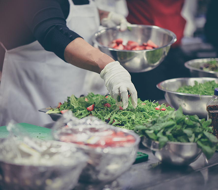 Chef hand tossing greens