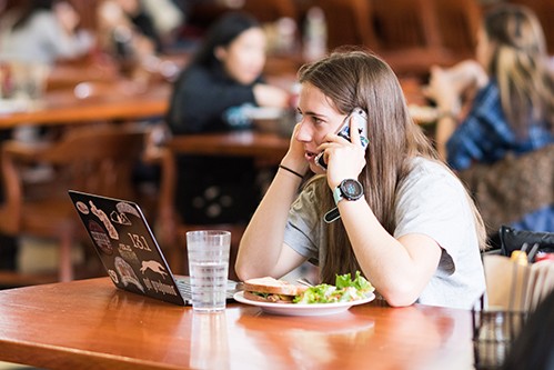 Student talking on the phone while eating