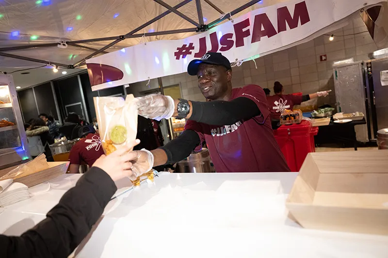 JJs staff member serving empanadas