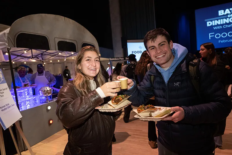 Students toasting with cups of sauce