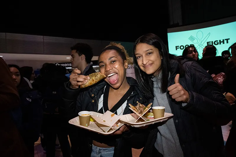 Students holding food and smiling