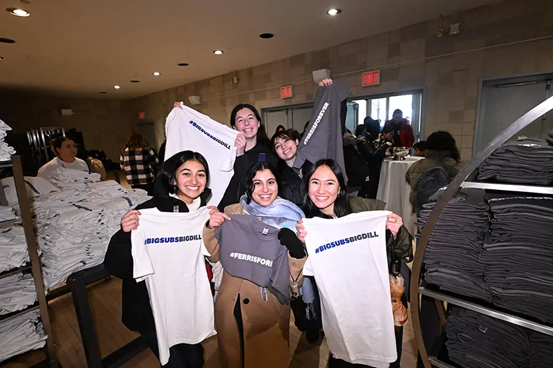 Students holding up t-shirts