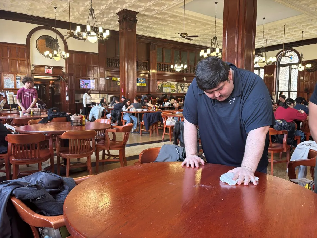 Joey wipes down a table in John Jay