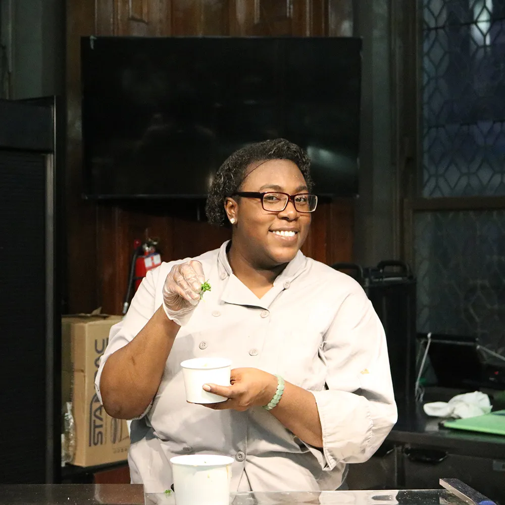 Jazmin holding a cup of chicken and dumplings