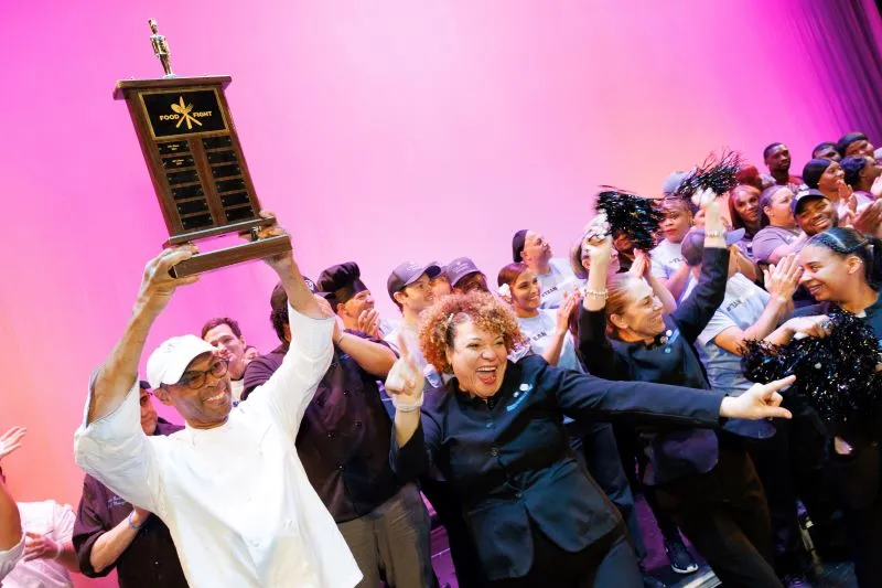 Faculty House staff holding the trophy and cheering