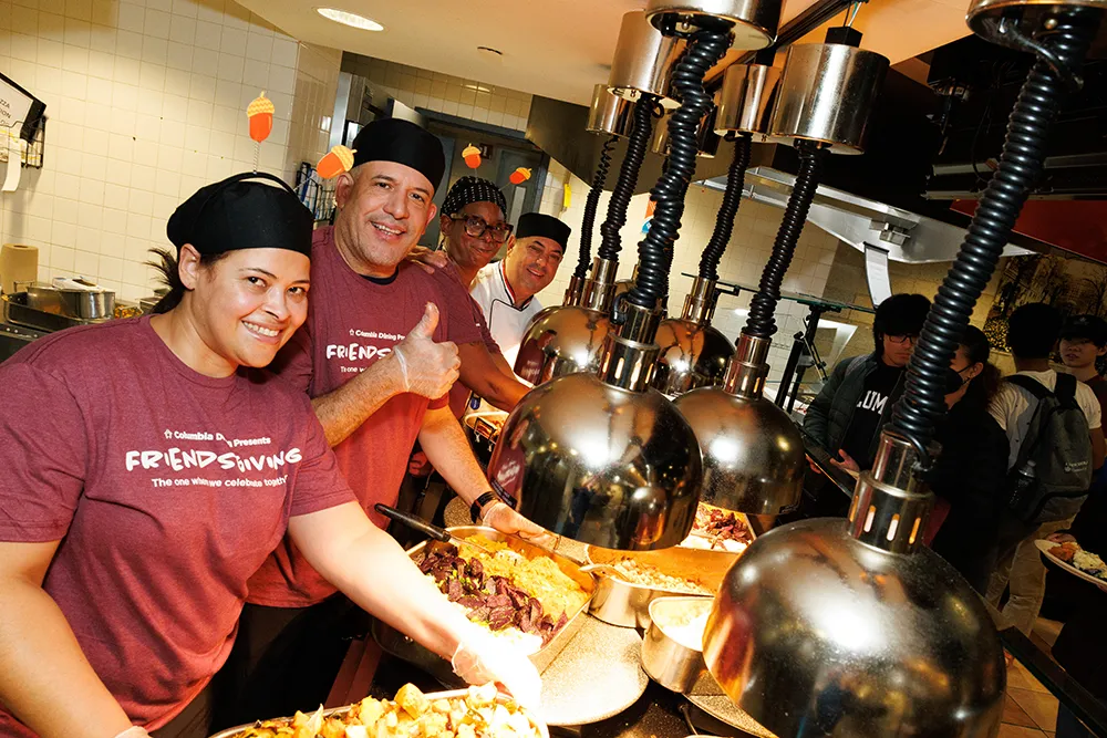 Staff serving food from behind the station