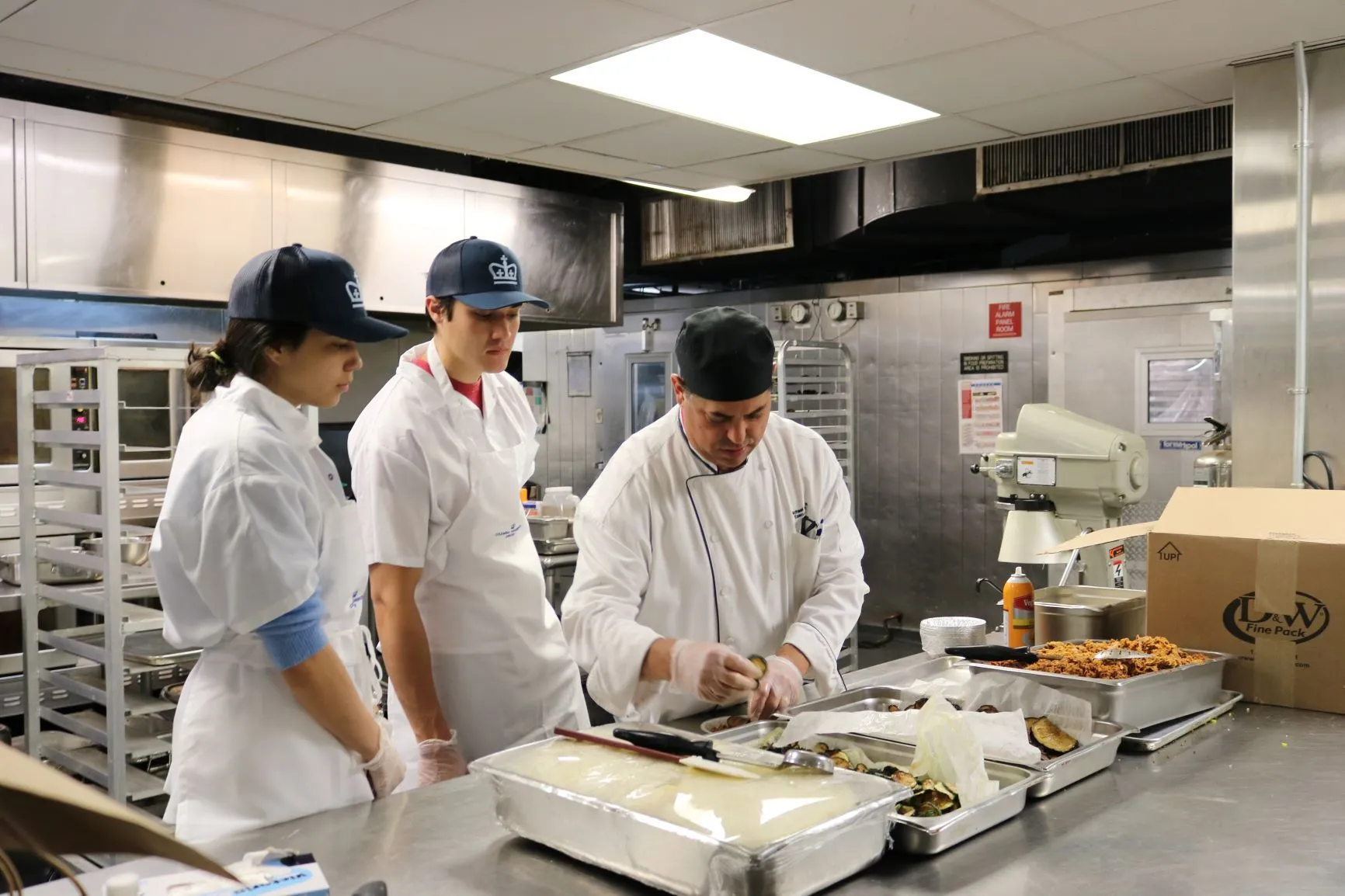 Chef Miks walks Teodora and John through the steps to build Moussaka