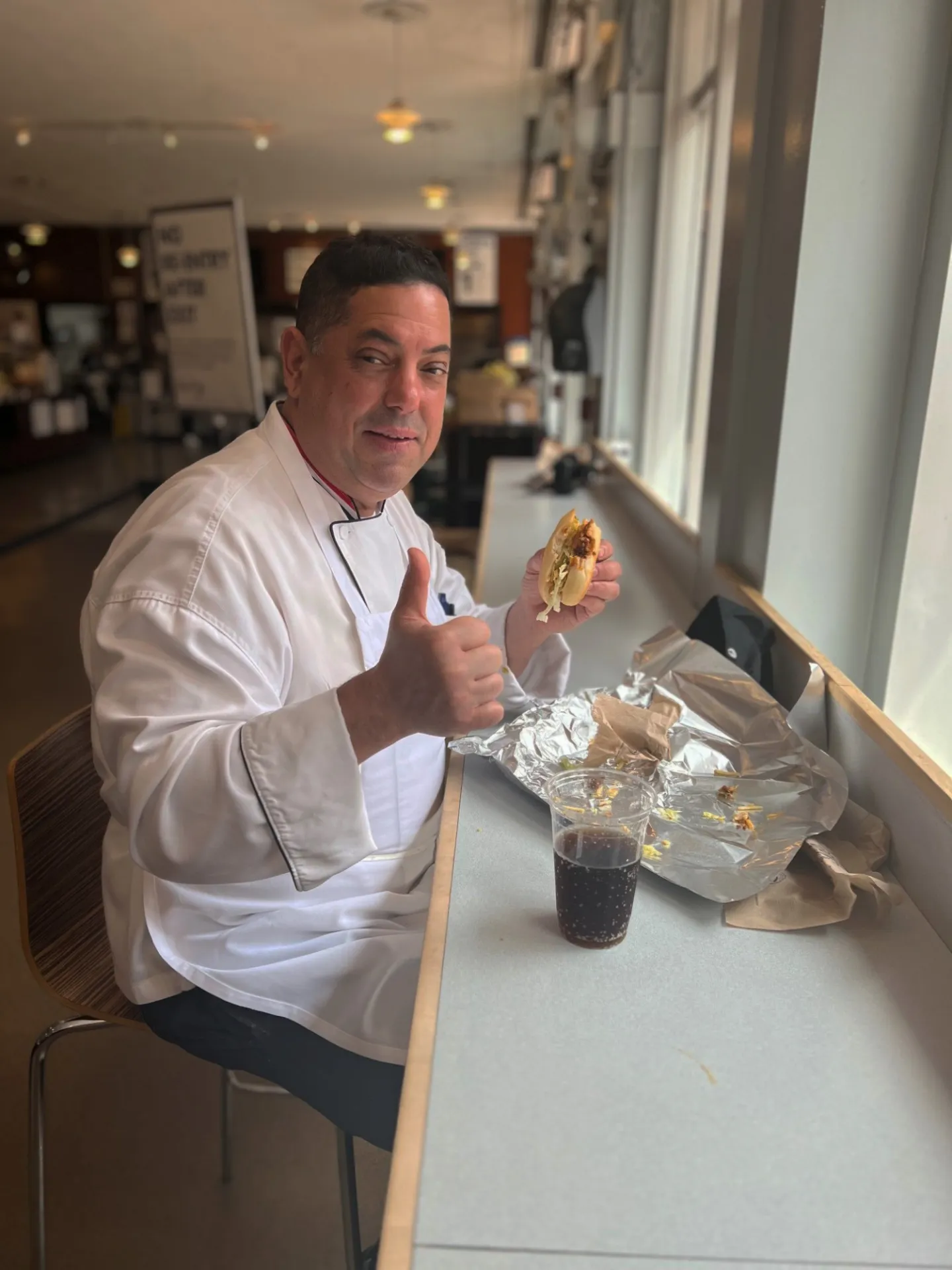 Chef Mike eating the sub and giving a thumbs up