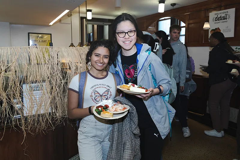 Students holding plates of food at John Jay