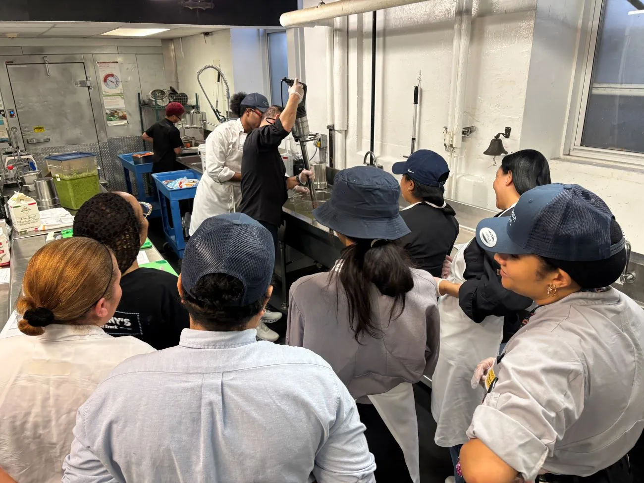 Staff member learns technique for cleaning a hand mixer
