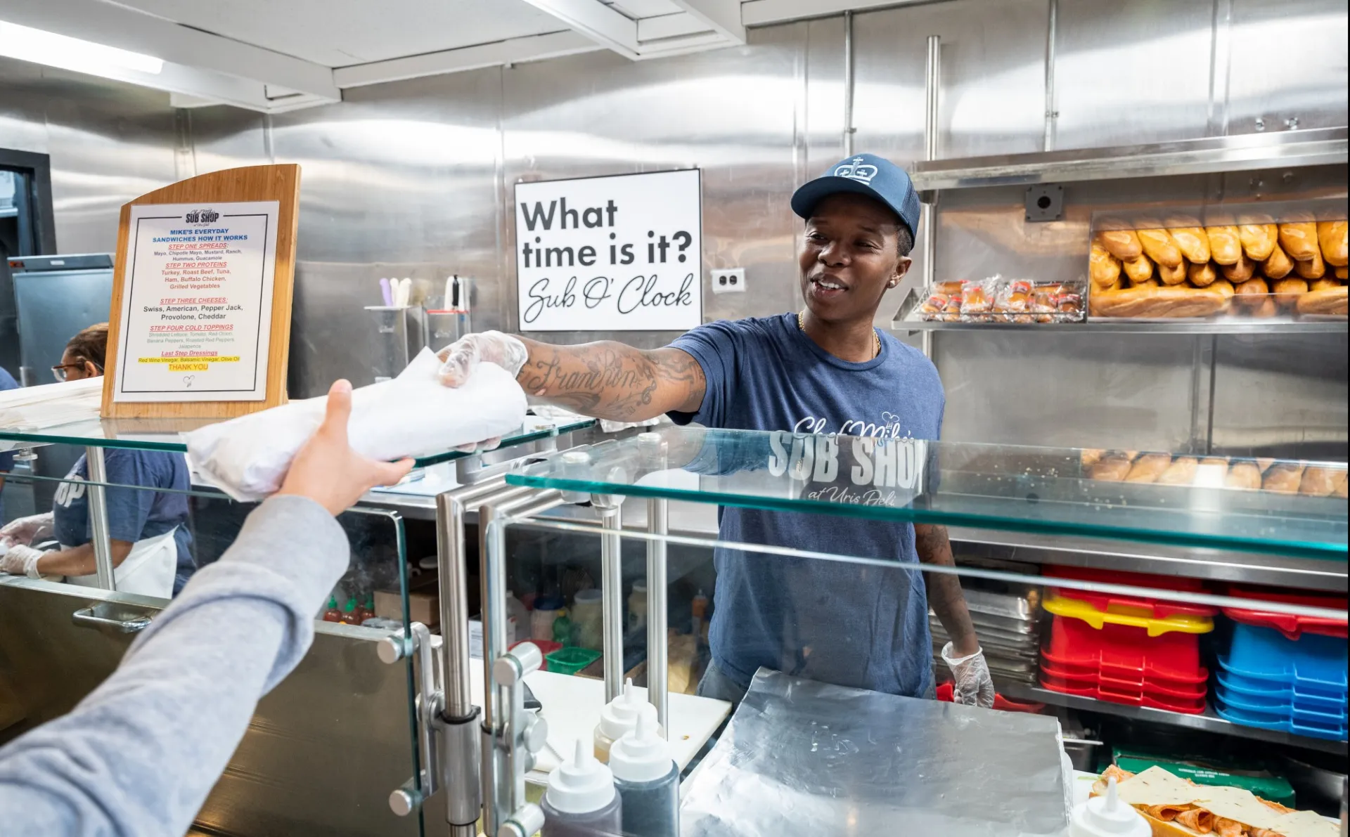 Staff member serving a sandwich to a customer