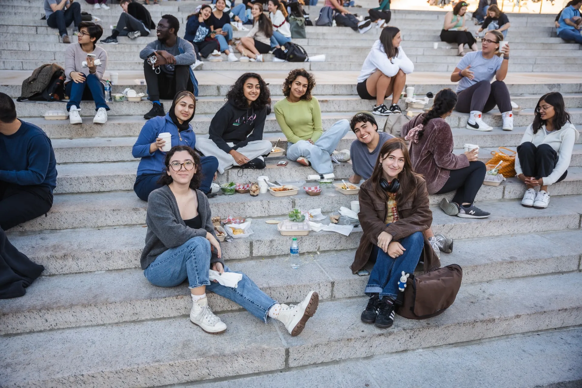 students sitting on the steps smiling