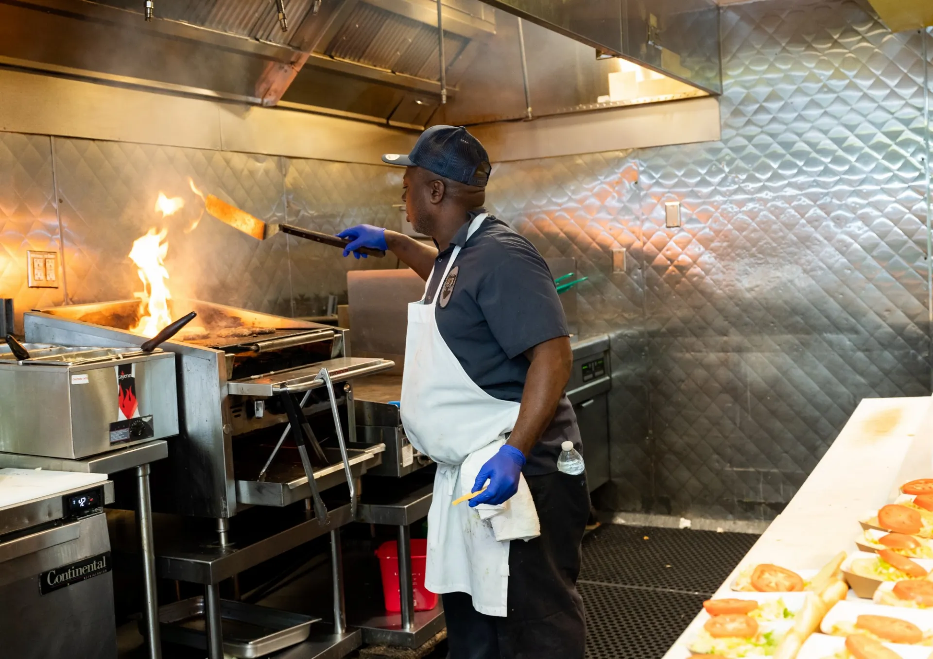 JJ's Place staff member grilling burgers