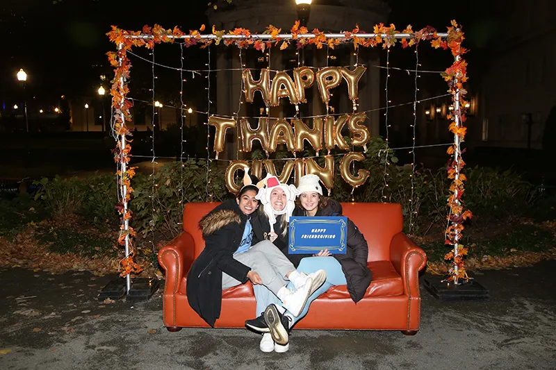 Students sitting on the couch at the photo booth